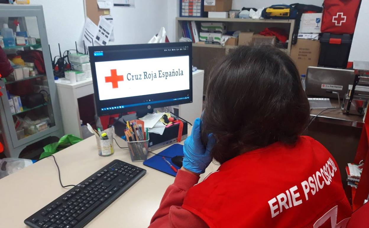 Una mujer del programa 'Cruz Roja te escucha' atiende una consulta telefónica 