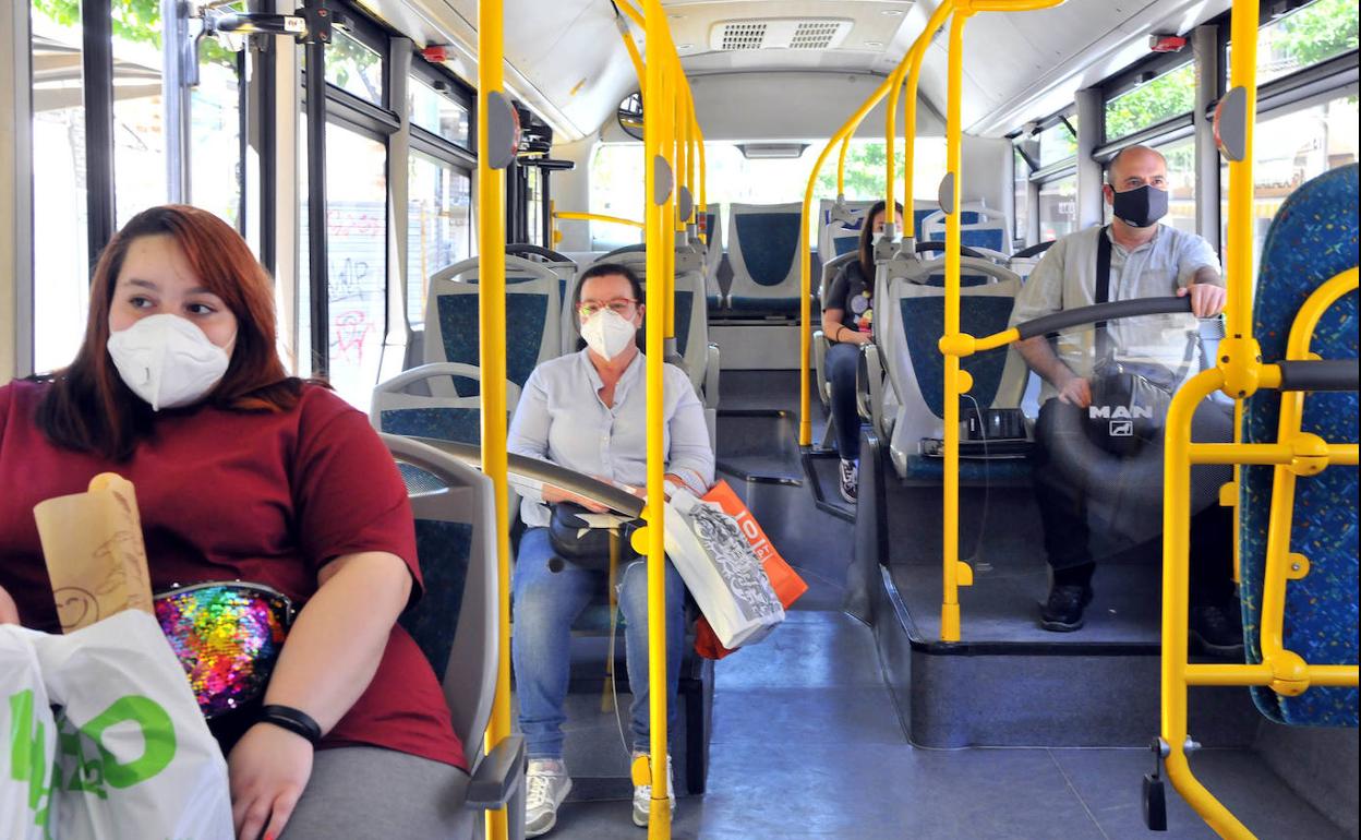 Usuarios con mascarillas en el interior de un autobús. 