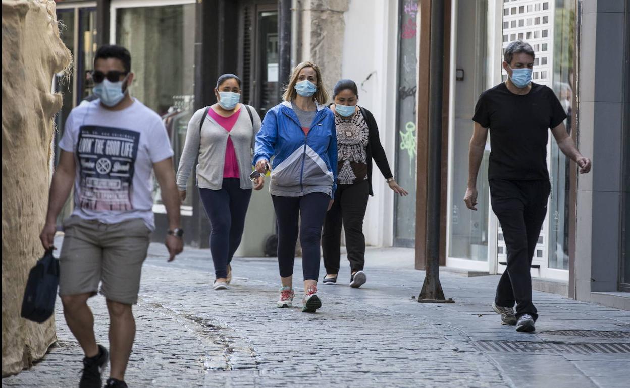 Gente con mascarillas en Granada. 