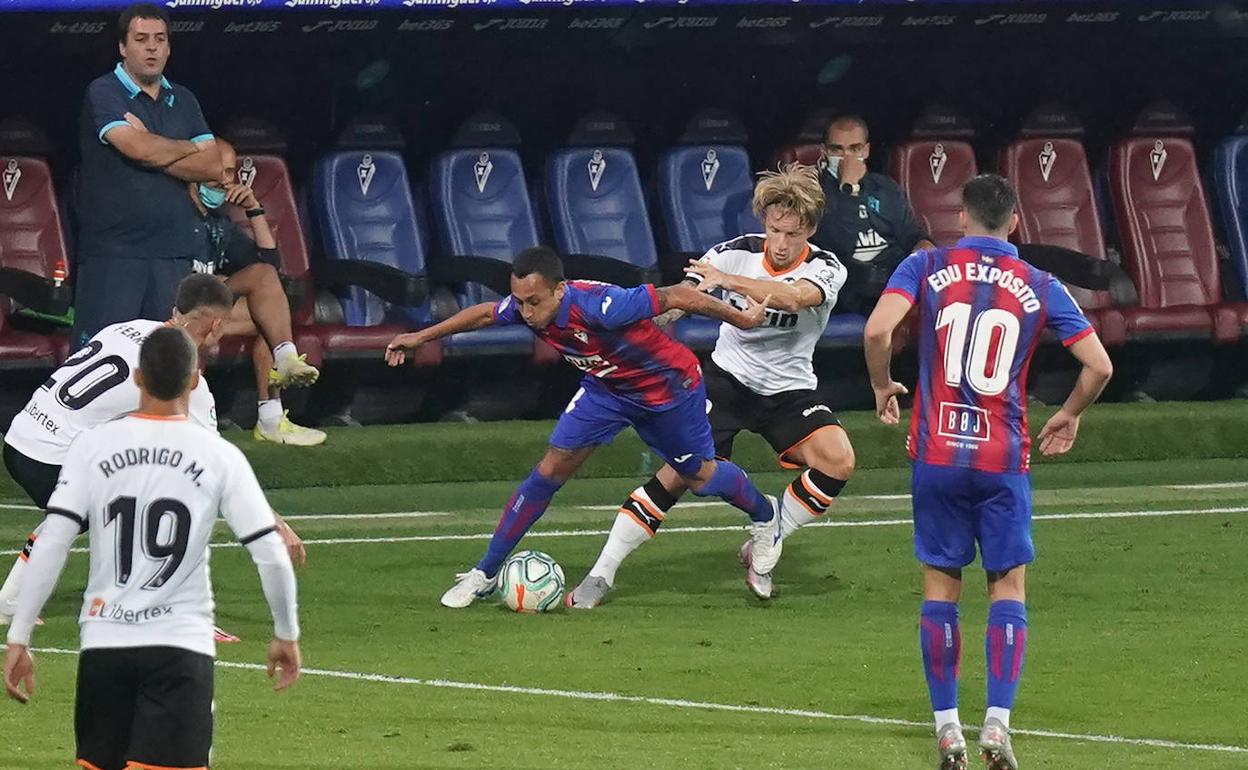 Fabián Orellana pugna con varios jugadores del Valencia en el partido disputado el jueves en Ipurua. 