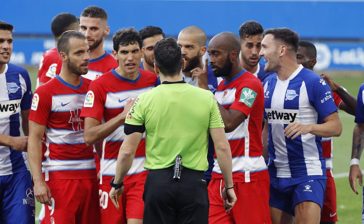 Los futbolistas del Granada y del Alavés rodean al árbitro durante el encuentro. 