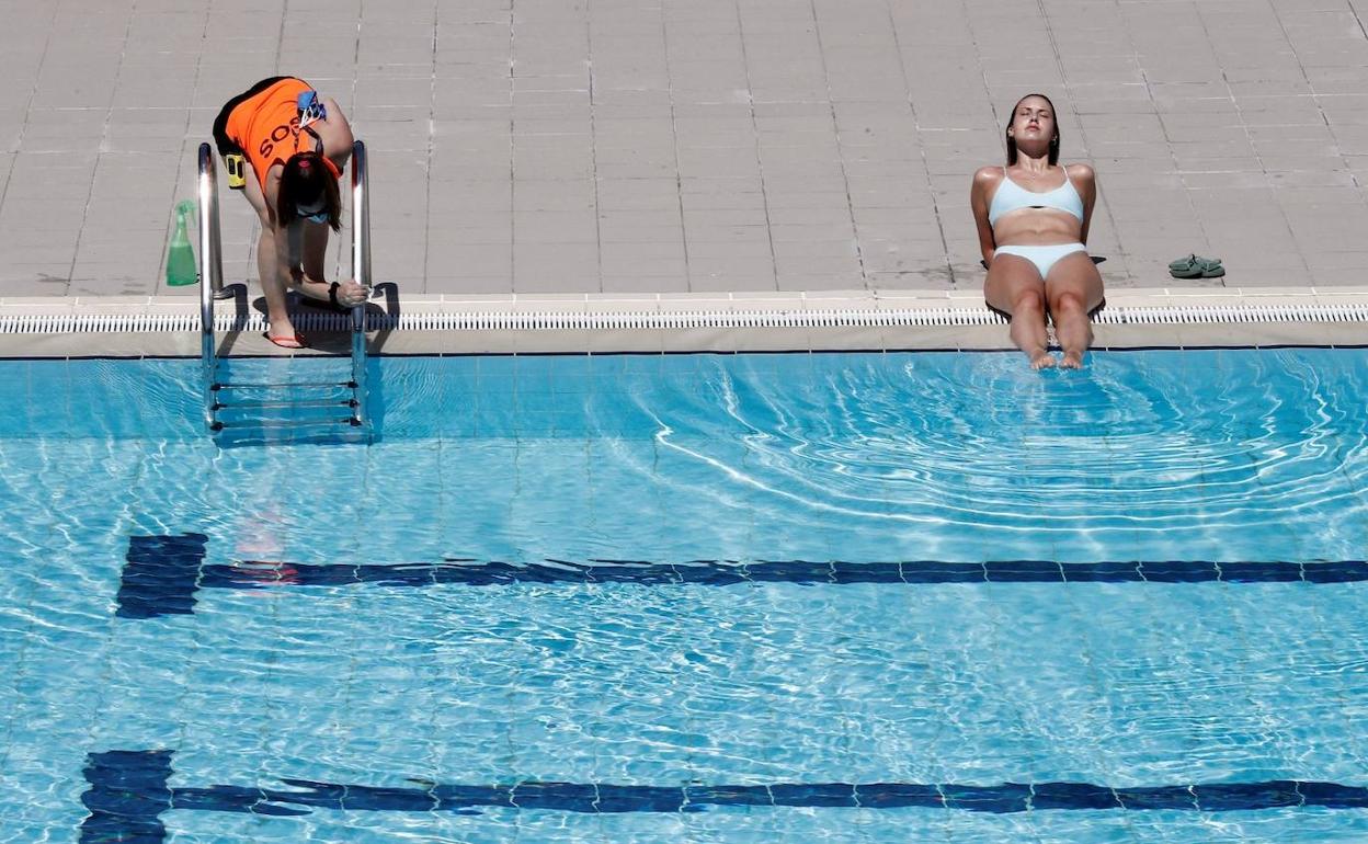 Socorrista en una piscina junto a una usuaria.