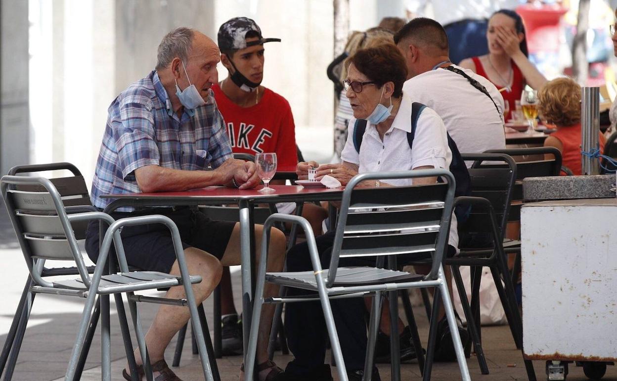 Un grupo de personas toma algo en una terraza en L'Hospitalet de Llobregat, Barcelona. 