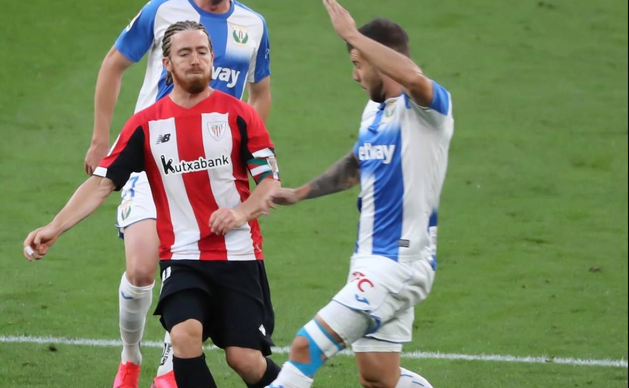 Iker Muniain recibe la entrada de Aitor Ruibal, con Eraso a la espalda, en el partido Athletic-Leganés. 