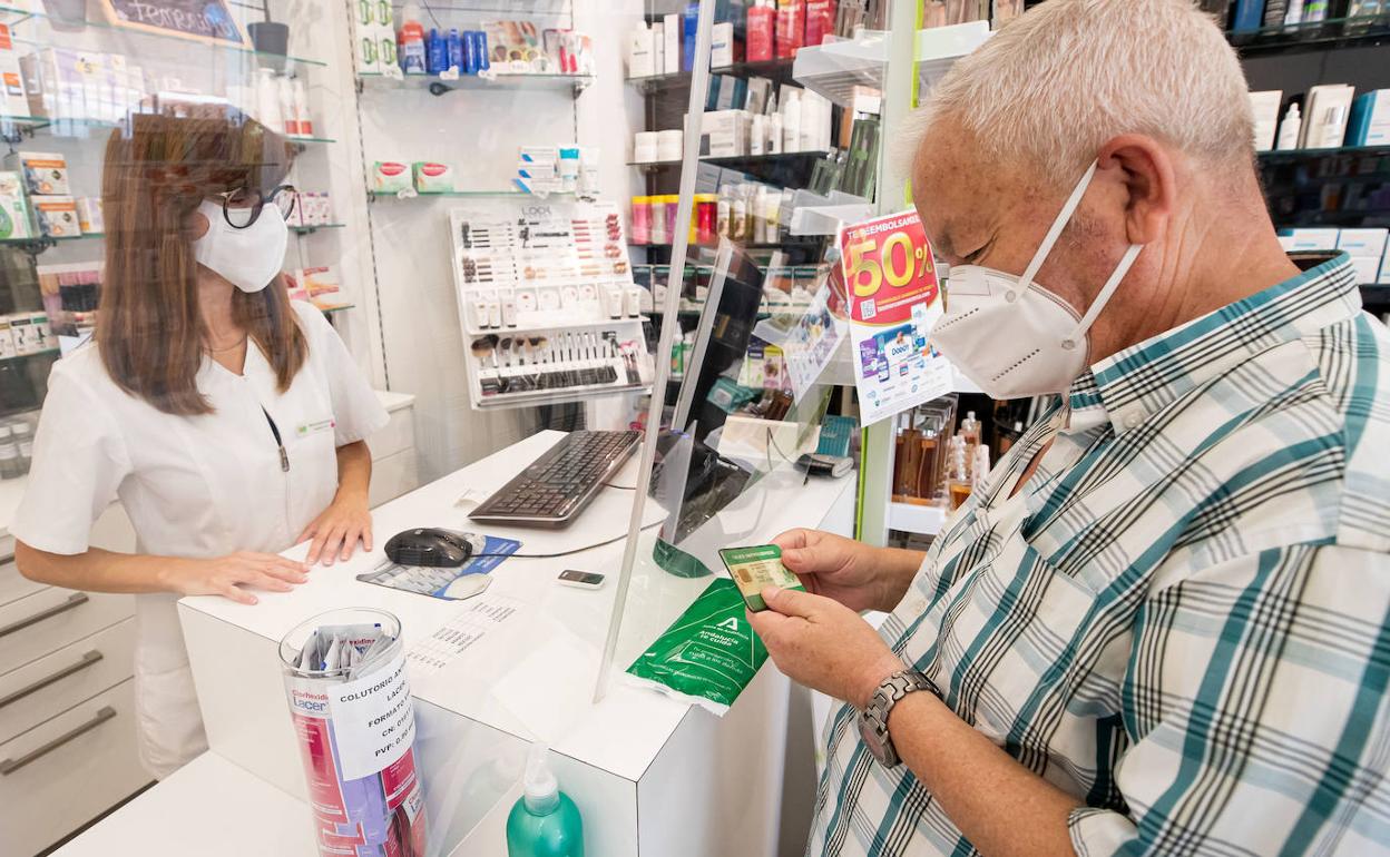 Una farmacia de Granada dispensa un paquete con tres mascarillas gratuitas de la Junta el pasado miércoles.
