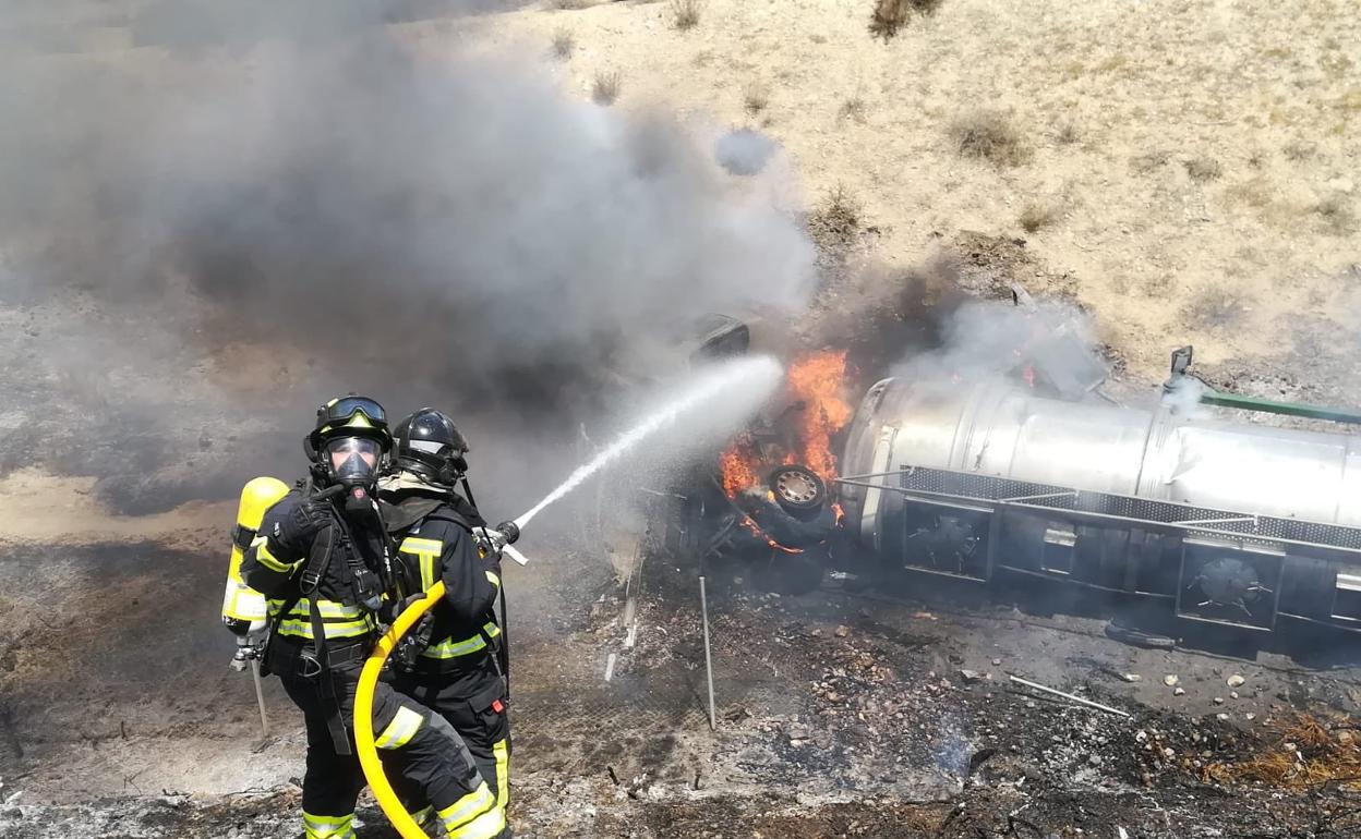 Los Bomberos de Almería sofocan el fuego en el camión siniestrado tras salirse de la vía en la A-7 a la altura de Viator.