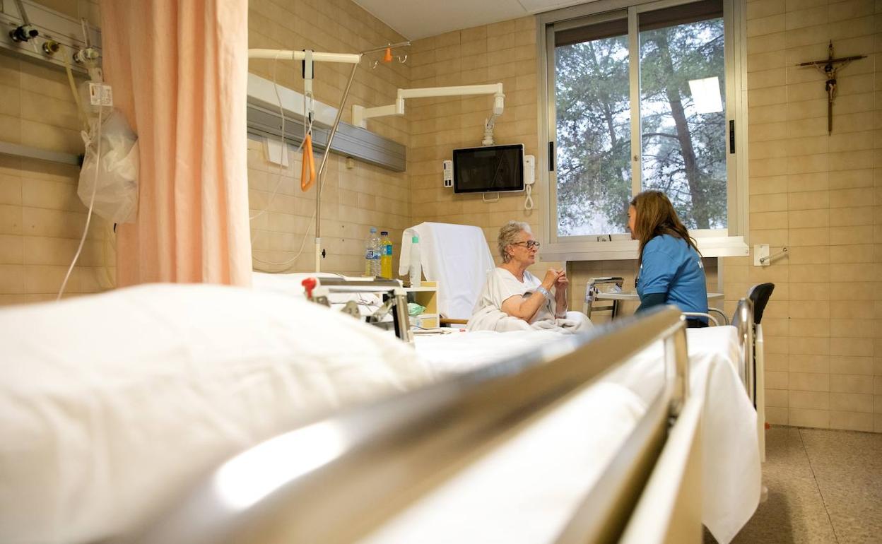 Una voluntaria acompaña a una mujer en el hospital.