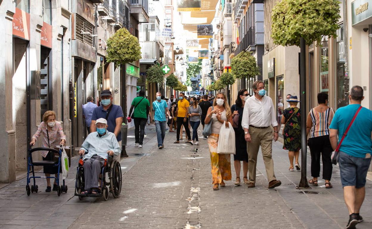Vecinos de Granada paseando con mascarillas por el centro.