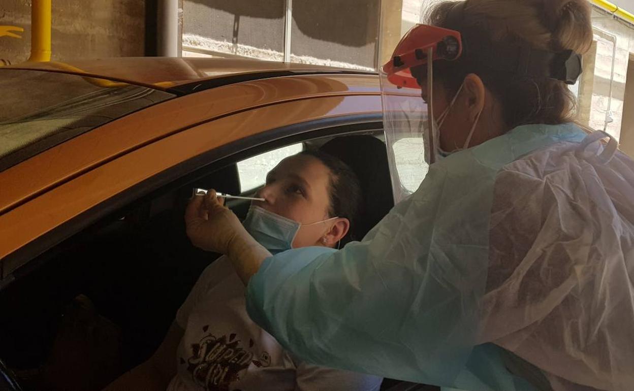 Prueba PCR a una mujer en su coche. 