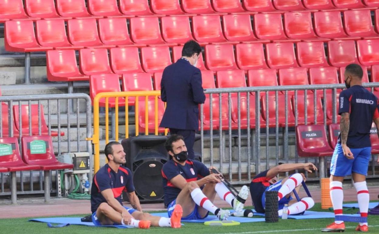 Soldado y Germán, sobre las esterillas, en los estiramientos previos al calentamiento. 