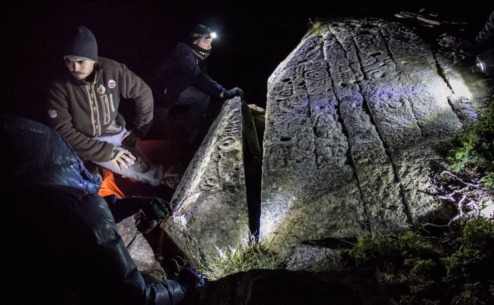 Investigadores, provistos de frontales, analizan el impresionante petroglifo hallado en Sierra Nevada.