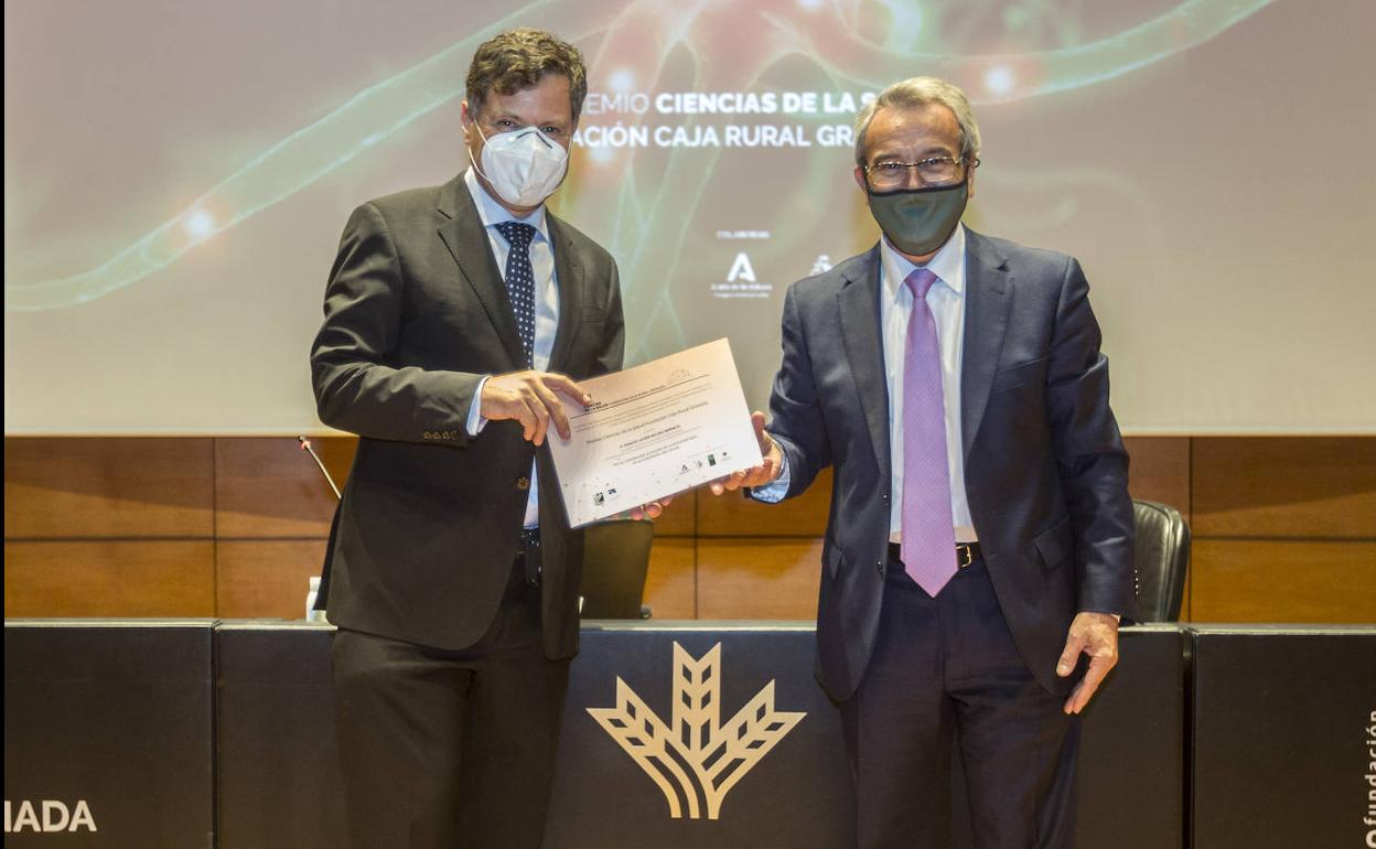 Ignacio Melero, a la izquierda, recibe el premio de manos del presidente de Caja Rural Granada, Antonio León.