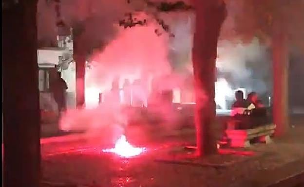 Una bengala cae junto a unos jóvenbes en la Placeta de Carvajales