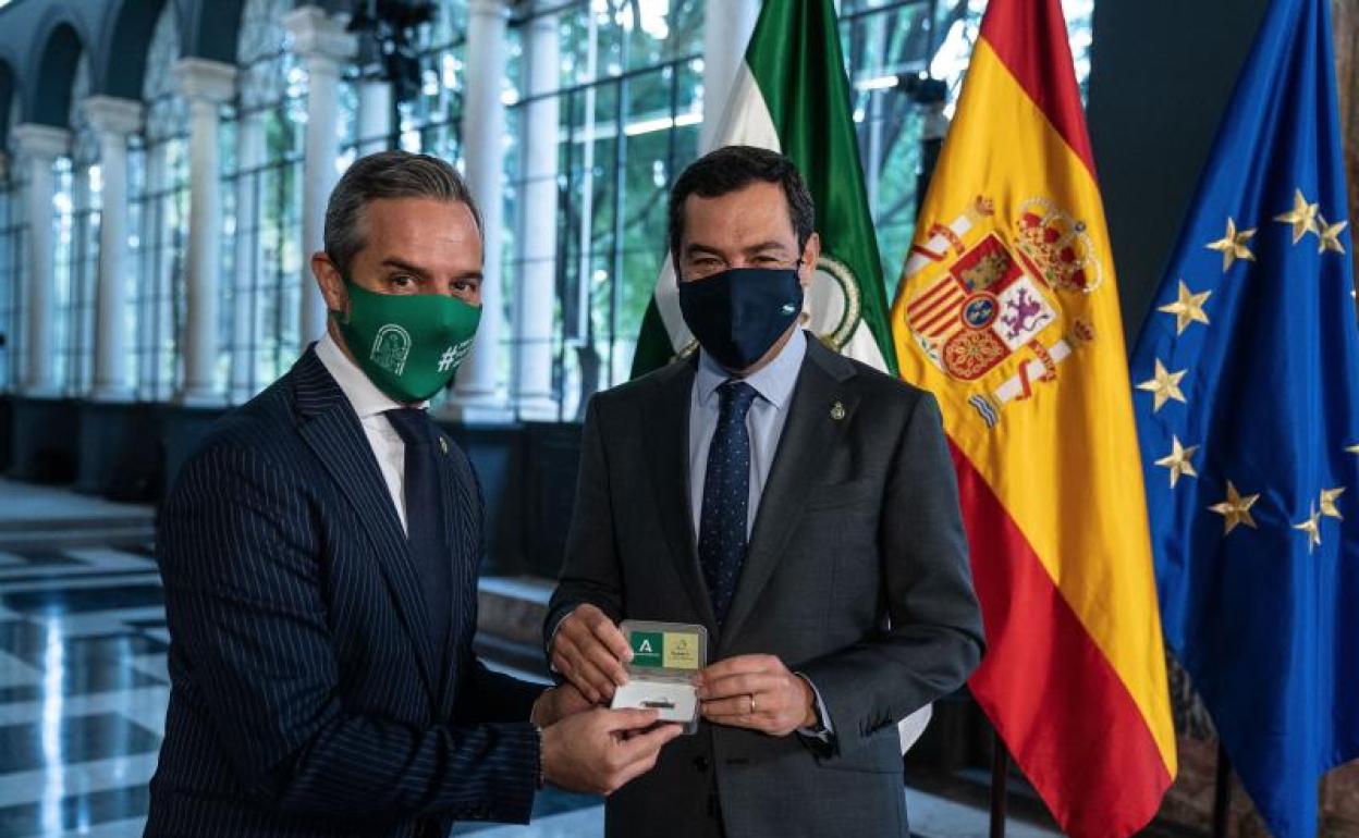 El presidente de la Junta de Andalucía, Juanma Moreno (d), junto al consejero de Hacienda y Financiación Europea, Juan Bravo, tras aprobar hoy miércoles el Consejo de Gobierno el proyecto de ley de presupuestos de Andalucía. 