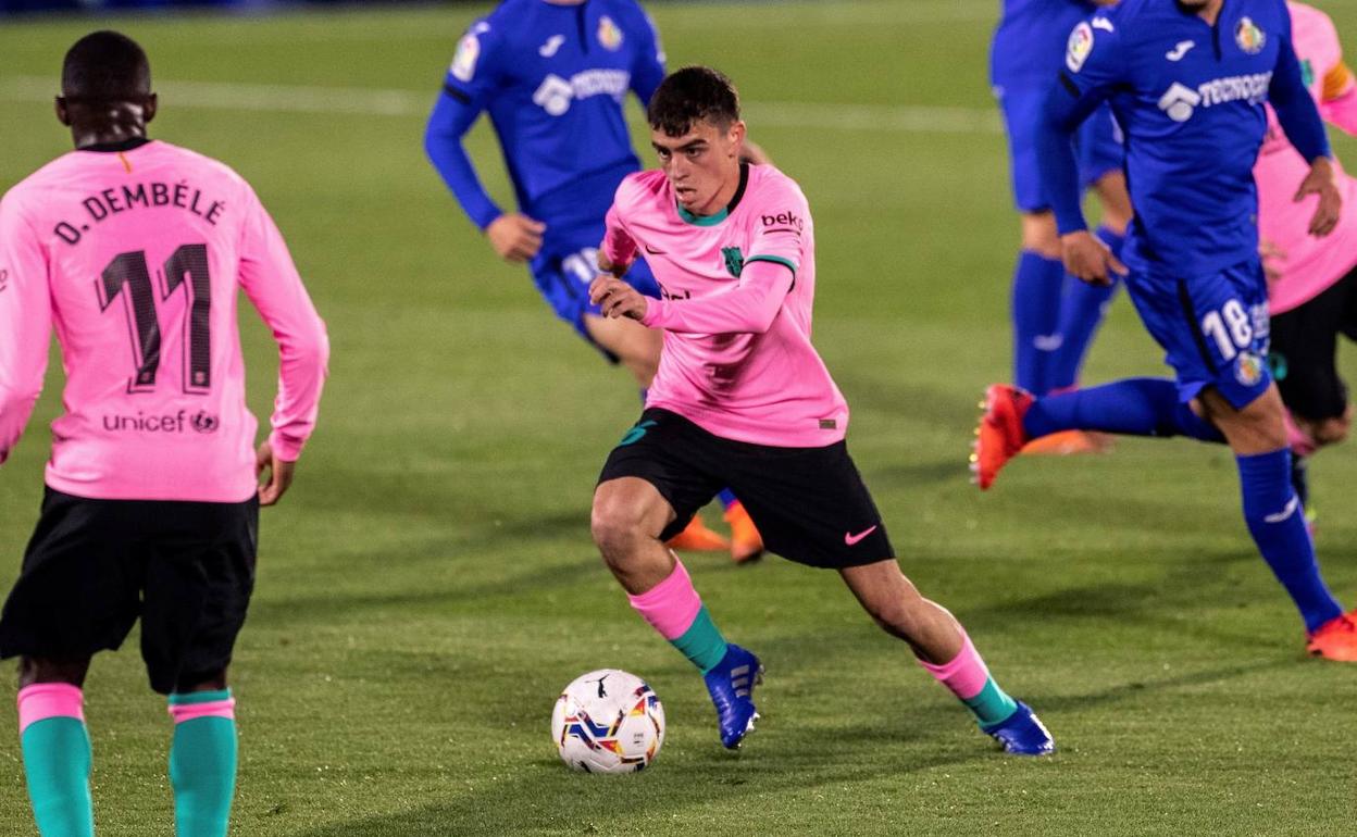 Pedri, futbolista del FC Barcelona, conduce un balón entre rivales del Getafe. 