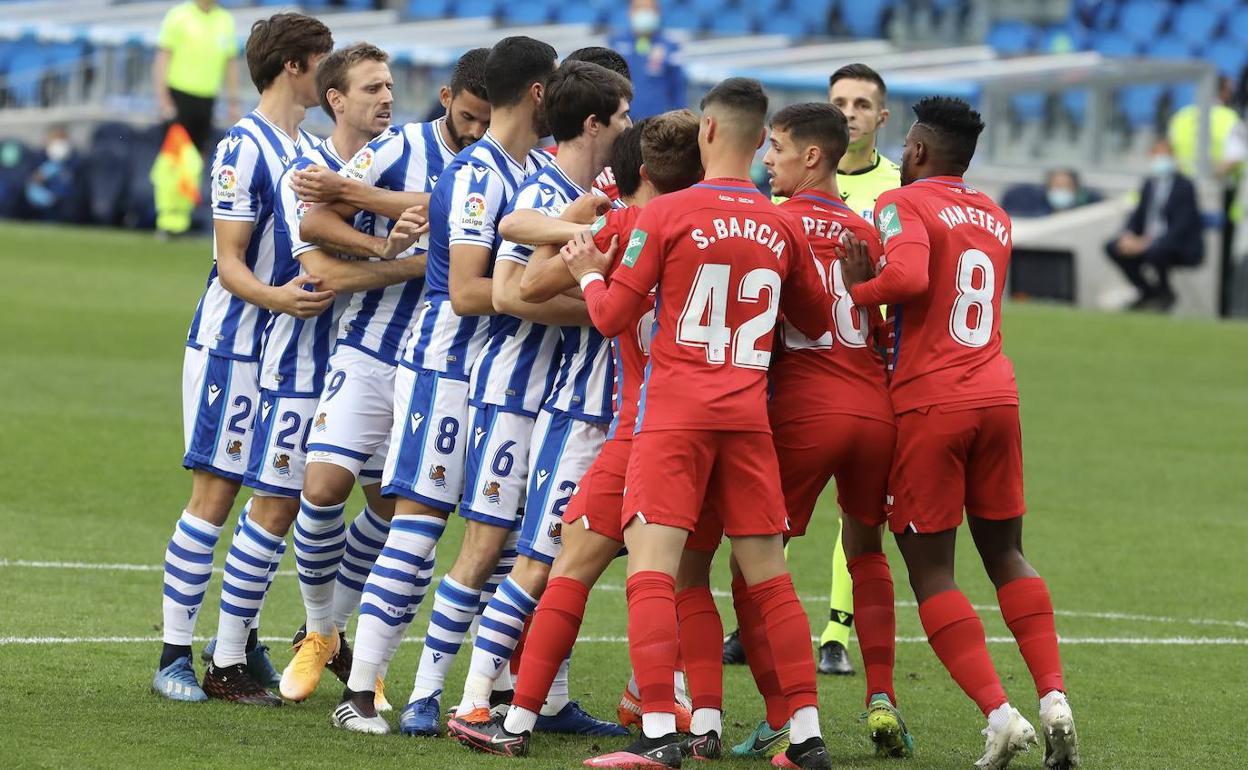 Futbolistas del Granada defienden a sus rivales de la Real Sociedad en el partido de San Sebastián. 