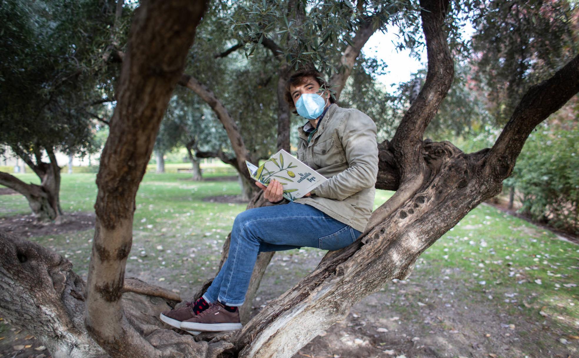 Emilio Fuentes posa con su libro, 'La aceitunilla Pepa', en el Parque García Lorca de Granada. 