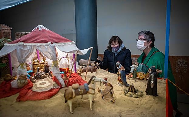 Galería. Dos mujeres observan el belén de la Federación de Caseteros. 