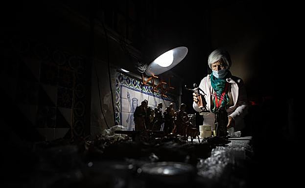 Imagen principal - Preparando el belén municipal, ya inaugurado. 