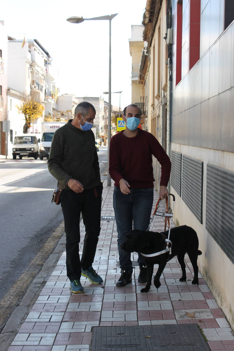 Con su instructor de movilidad con perros guía de la ONCE, repitiendo el recorrido que hará a diario con su nuevo can hasta su quiosco. 