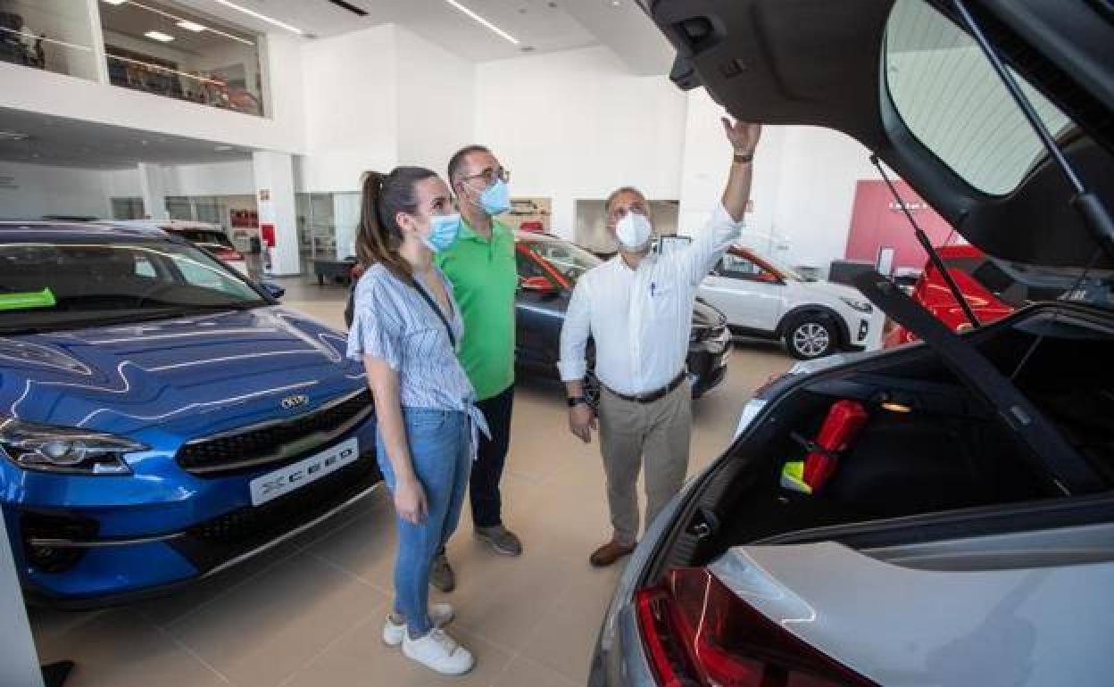 Dos usuarios se interesan por un vehículo en un concesionario KIA en Granada. 