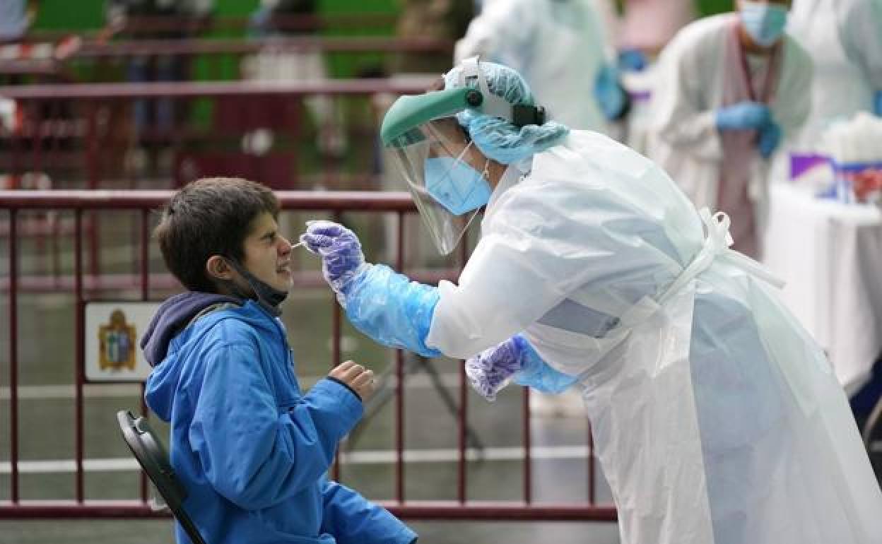 Una sanitaria realiza una PCR a un niño. 