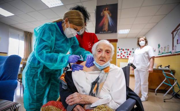 Imagen principal - En la primera imagen, Carmen recibe, a sus 96 años, la dosis de Pfizer, tras haber sobrevivido al coronavirus. En la segunda fotografía, Rubén, Mariola, Pepa, Lola y Víctor, el equipo encargado de vacunar a una de las últimas residencias.