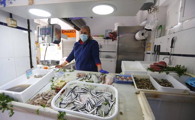 Imagen principal - Angi, pescadera del mercado municipal, ha reabierto este jueves. Un jubilado de 86 años ensea sus papeles con lso que ha pedido una ayuda para arreglar los desperfectos de su casa por el terremoto. Un santaferino espera ser atendido en la puerta de la Oficina de Atención a los Damnificados de Santa Fe,