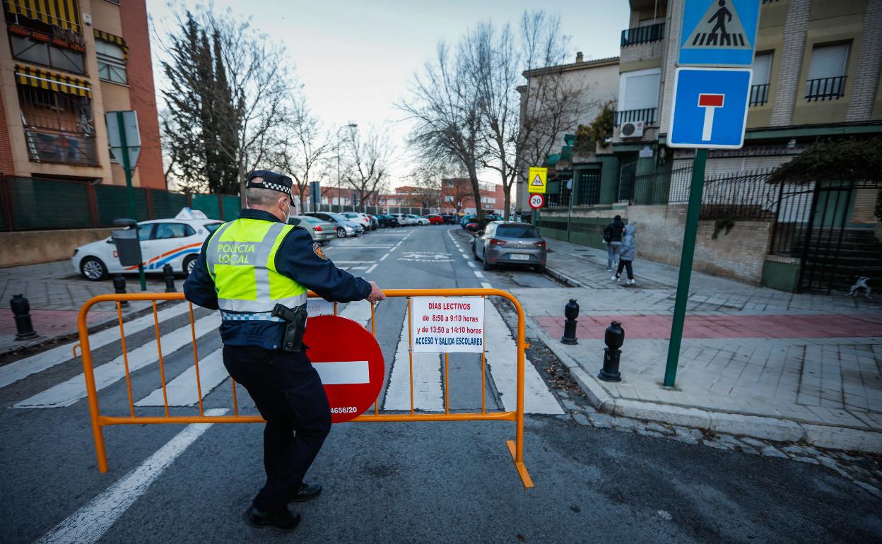 Un policía corta una calle en Granada.