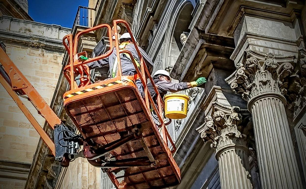 Los trabajadores aplican consolidador de piedra en la portada del Sagrario.