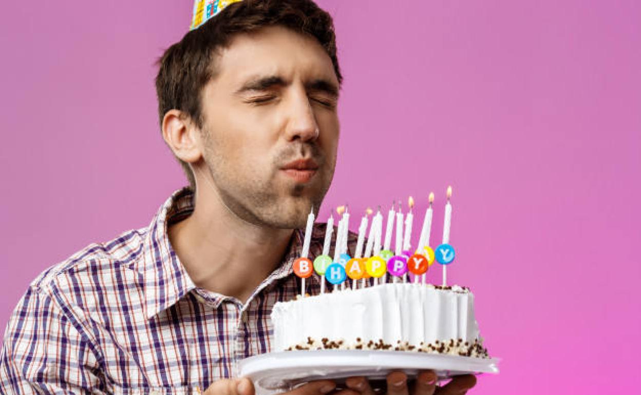 Hombre soplando las velas de aniversario