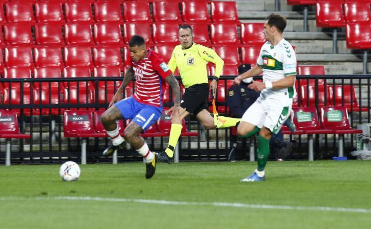 Kenedy conduce un balón por la banda ante un jugador del Elche. 