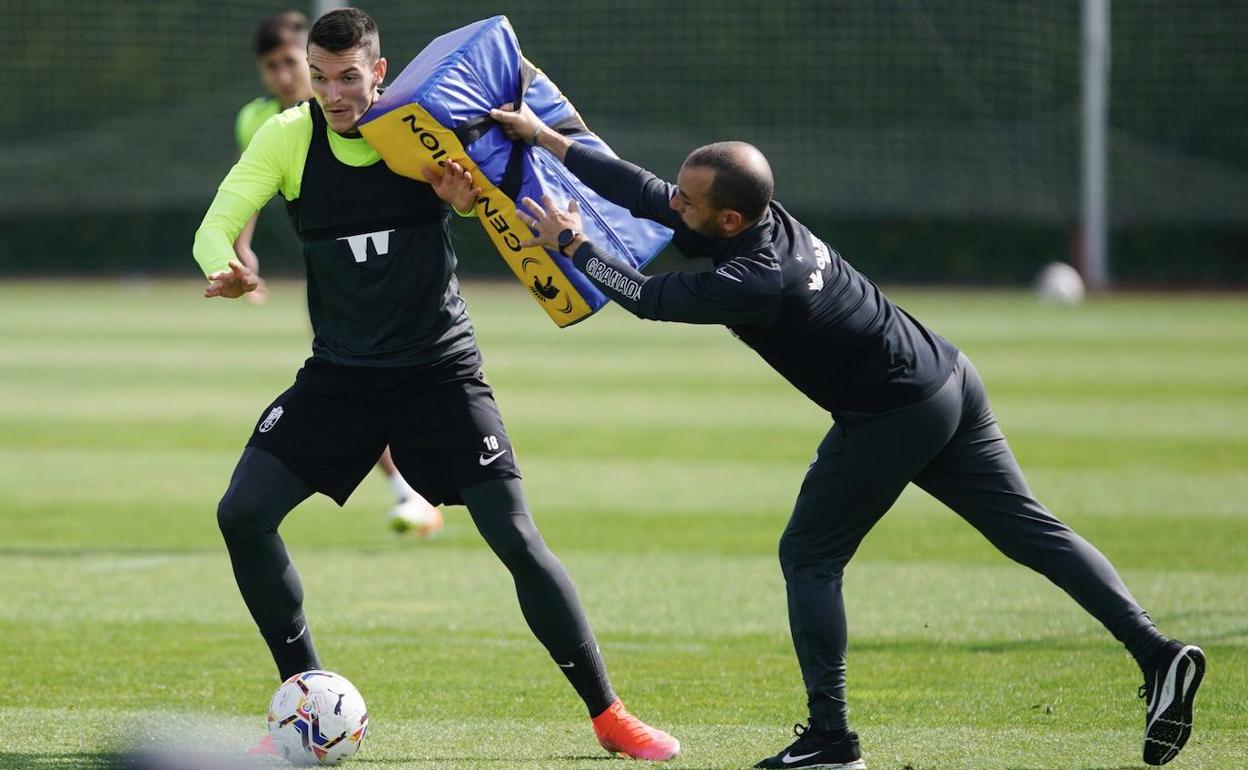 Adrián Marín resiste la acometida de Jesús Roche, miembro del cuerpo técnico. 