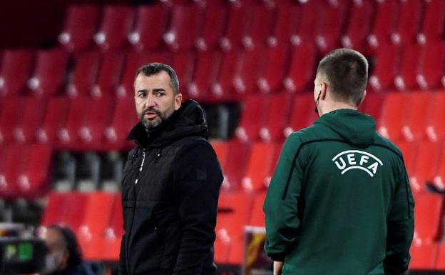 Diego Martínez escucha las observaciones del cuarto árbitro en el partido Granada-Molde. 