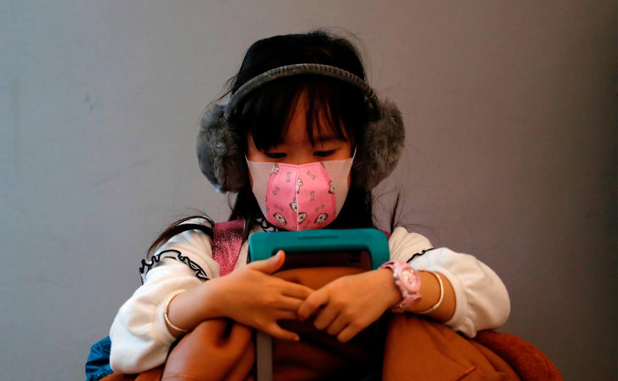 Niña en Hong Kong con mascarilla puesta.