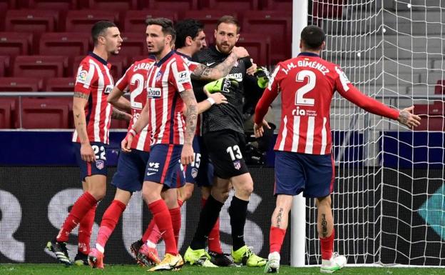 Los jugadores del Atlético felicitan a Oblak tras detener el penalti a Joselu.