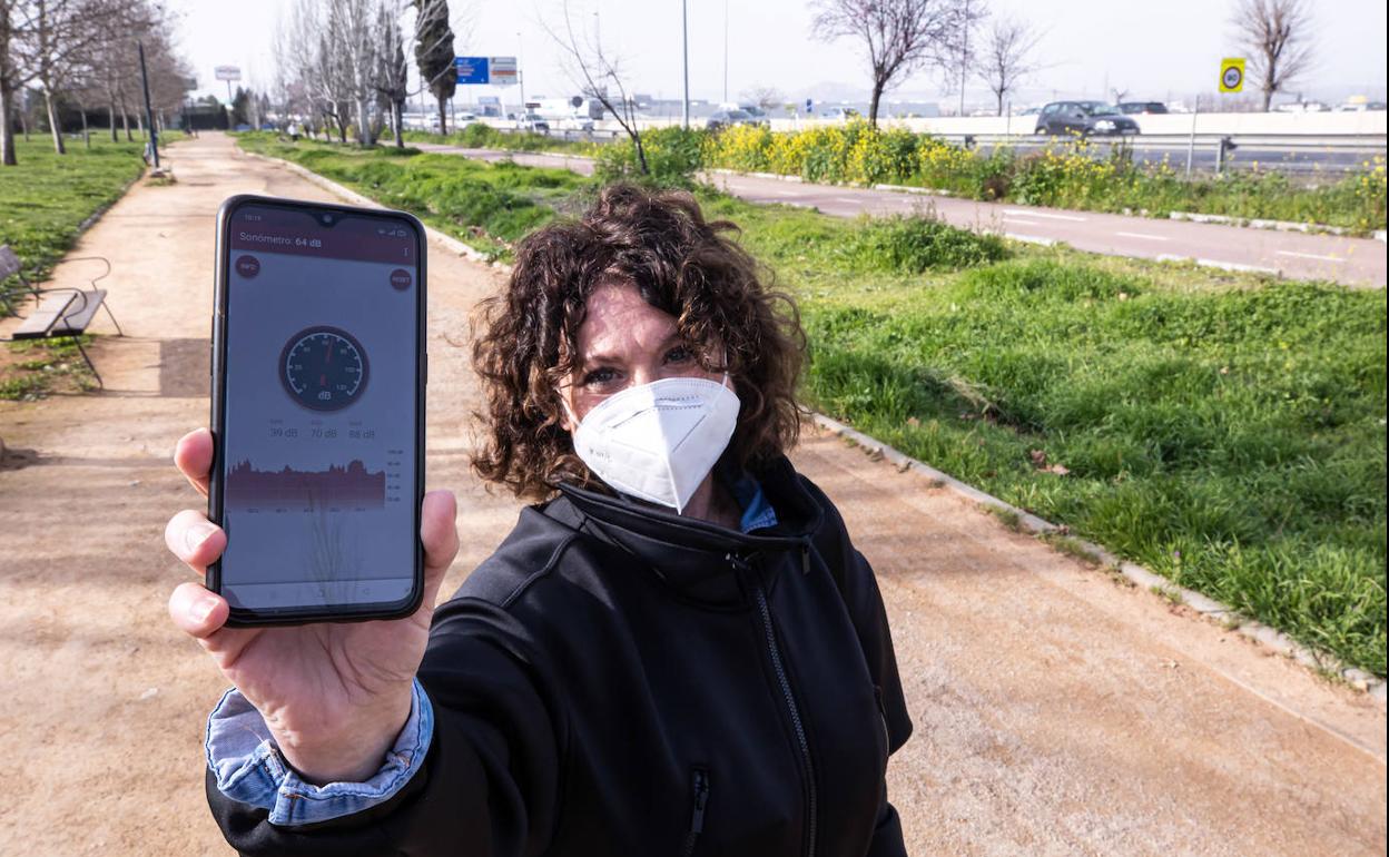 Una vecina muestra la medición de ruido junto a la autovía en su teléfono móvil. 