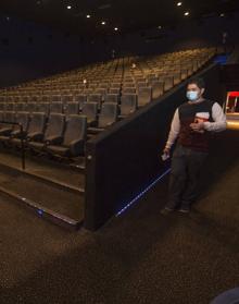 Imagen secundaria 2 - Carlos, con sus entradas para la sesión doble y el cubo de palomitas. La sala, antes de empezar. 