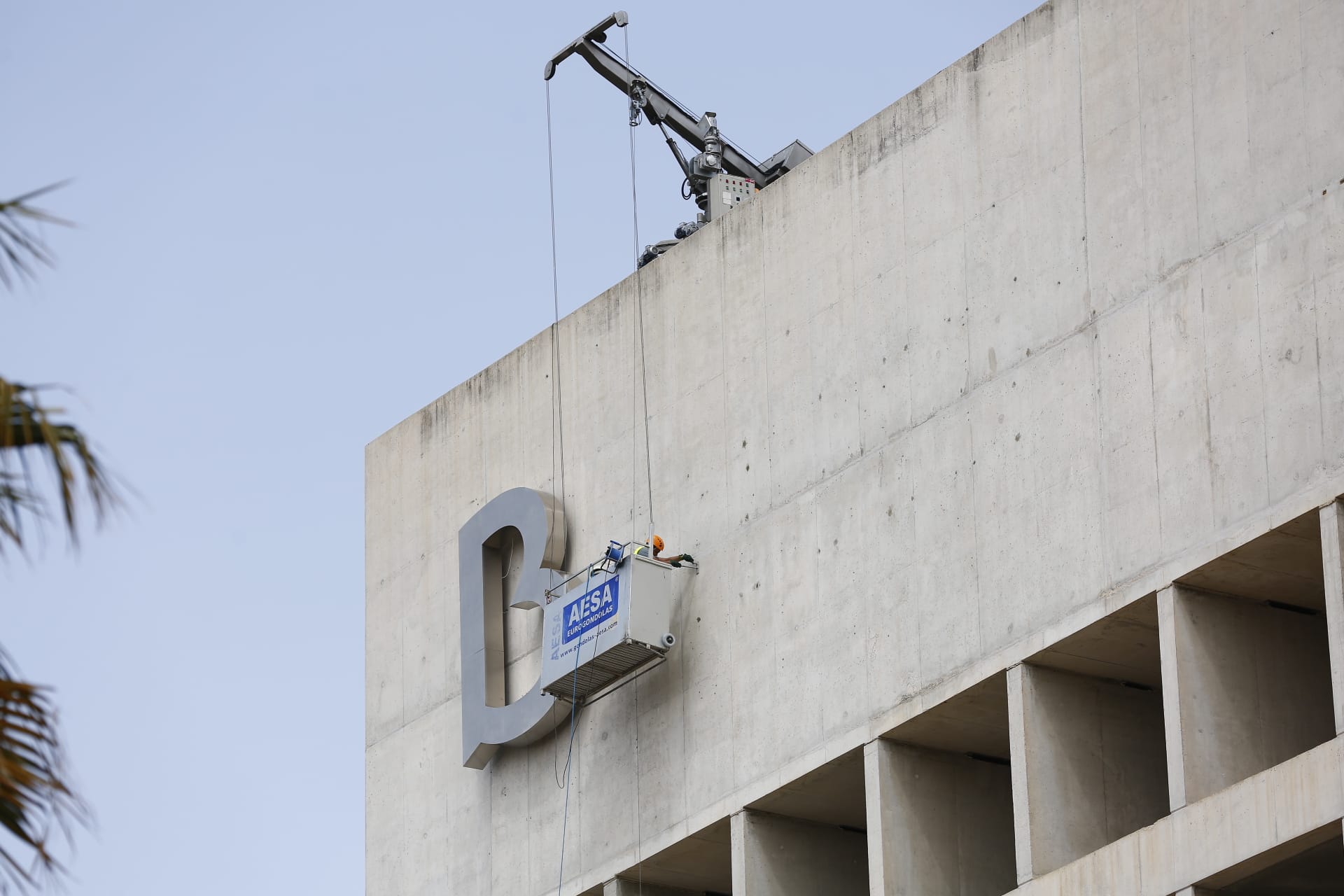 La emblemática sede bancaria está retirando hoy el logo y colocando el nuevo