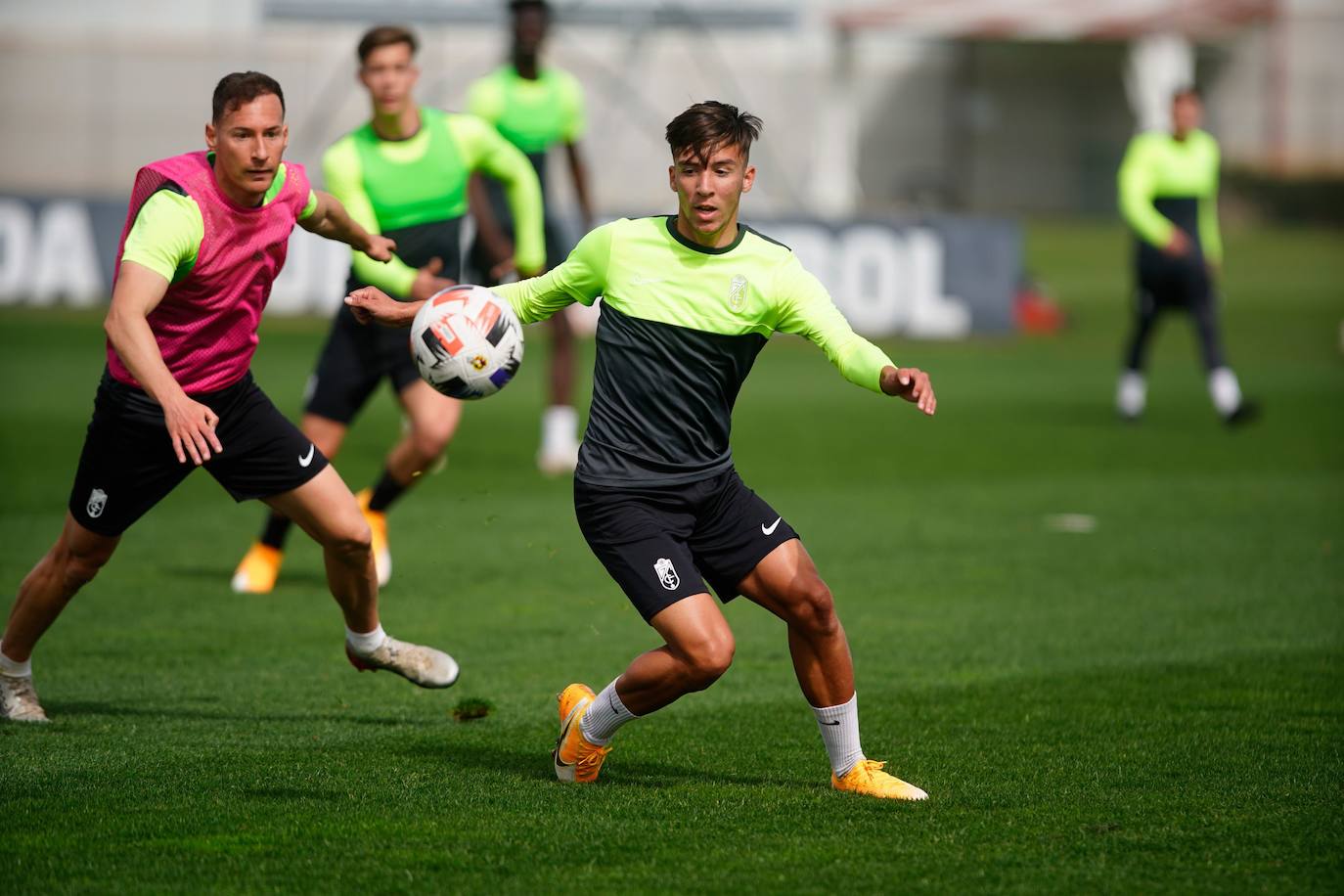 Mario (en primer plano) intenta controlar un balón ante la presión de su compañero Migue García. 