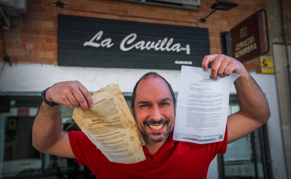 Israel muestra a la izquierda una hoja con ordenanzas del siglo XVI y en la derecha la licencia de apertura actual.