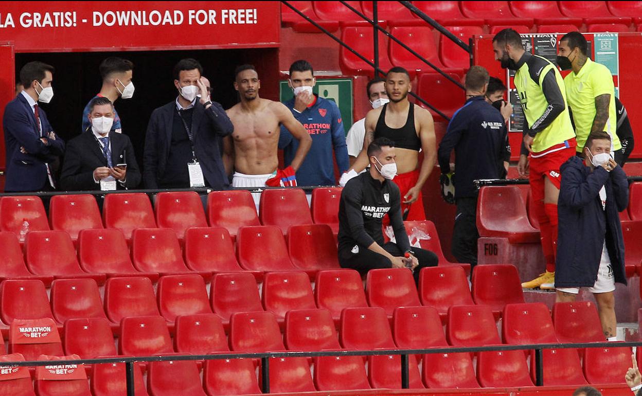 Miembros del Sevilla y el Granada alucinan en la grada al tener que regresar al campo. 