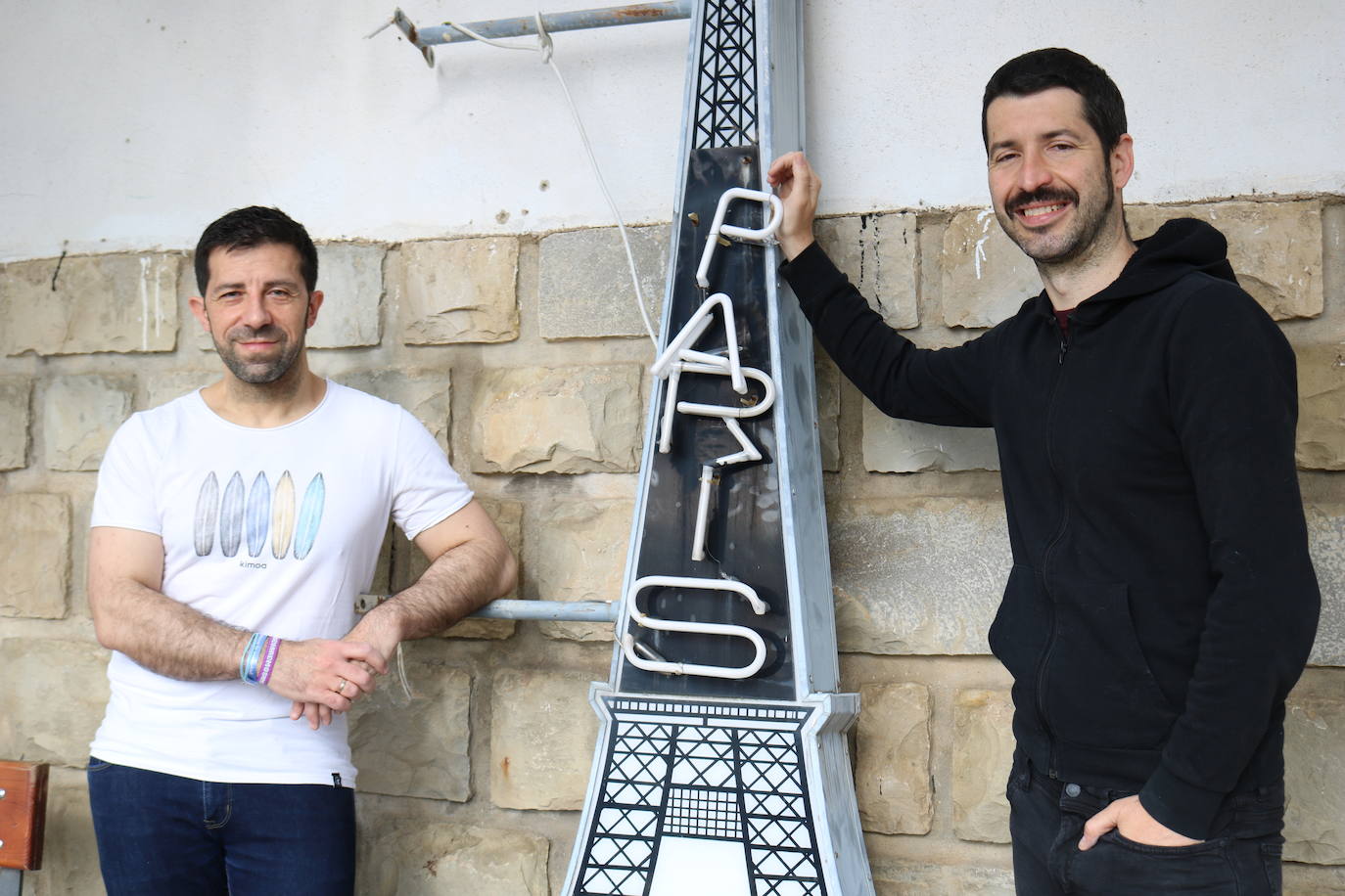 Juan y Carlos posan con un letrero de la Taberna París