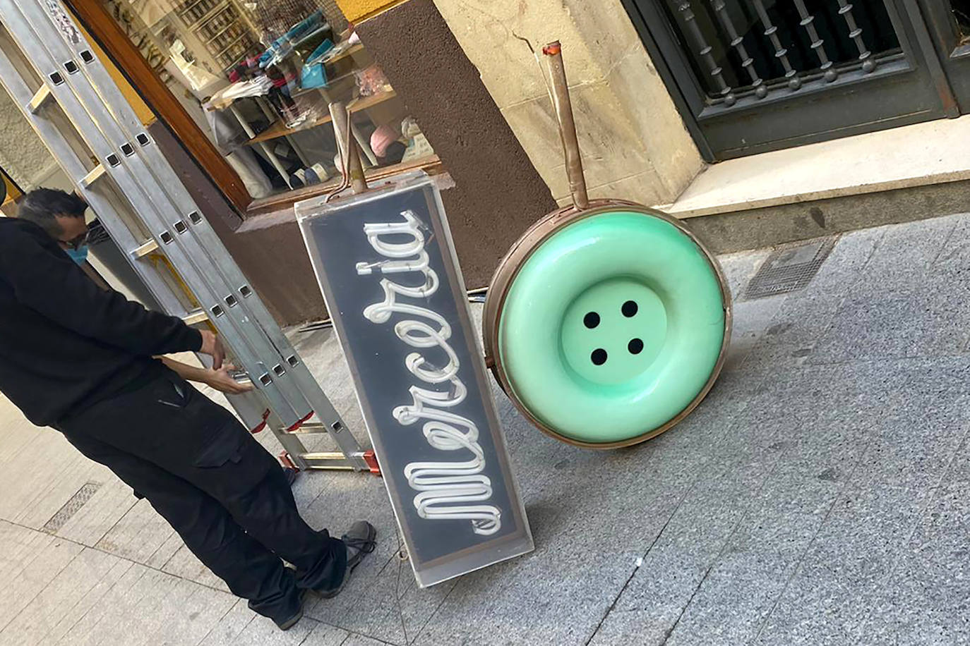 Juan y Carlos posan con un letrero de la Taberna París