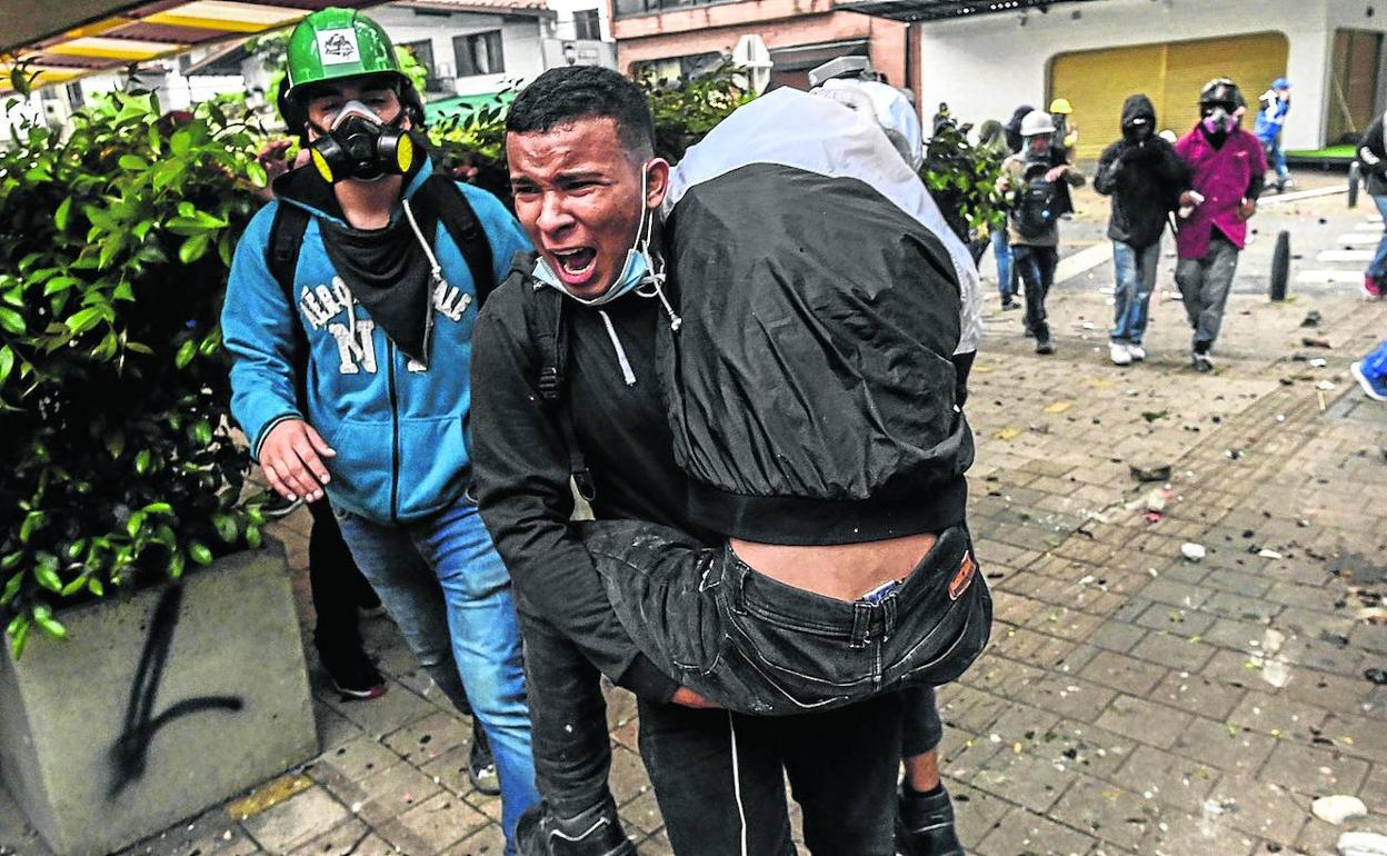 Evacuación de un joven herido por disparos de la Policía en Medellín.