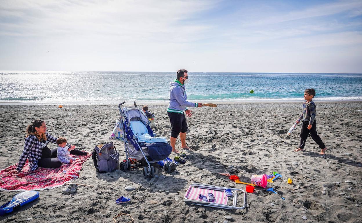 Una familia juega en la playa. 