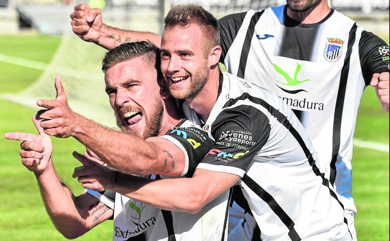 José Higón (en el centro) abraza a Ferrón celebrando un gol del Badajoz junto con Petcoff. 