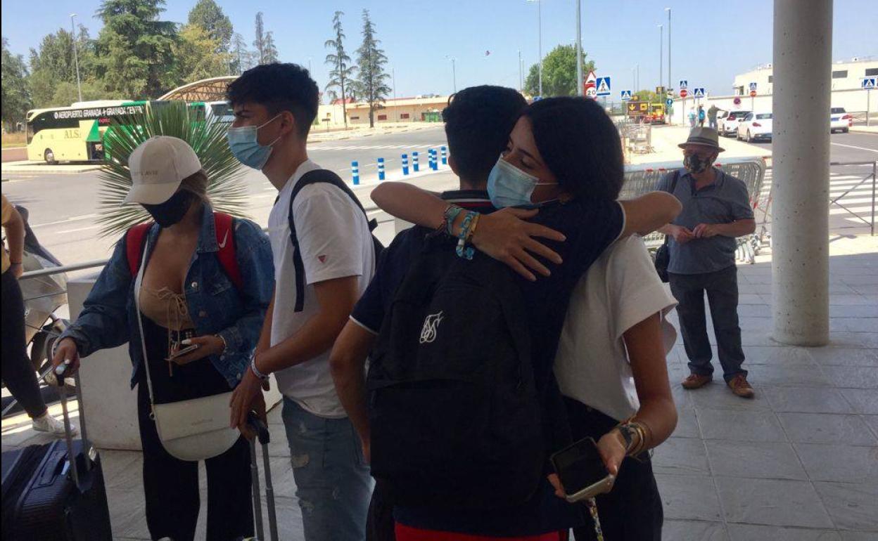 Miguel Ángel y Elena, dos de los estudiantes granadinos que han estado confinados en Mallorca, se abrazan en el aeropuerto de Granada. 