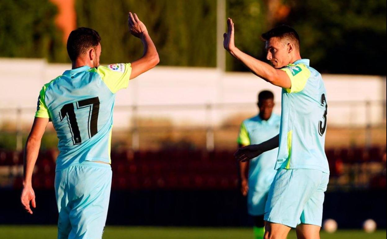 Quini (izq) choca los cinco de su compañero Adrián Marín. 