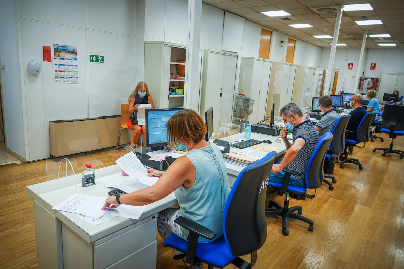 Los funcionarios del órgano de guardia, en la hilera de mesas de la estancia, donde harán turnos para cubrir las 24 horas.